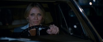 Movie still from “Knight and Day” (2010), directed by James Mangold – A woman sitting in the drivers seat of a car at night; Close Up shot, Over the shoulder angle