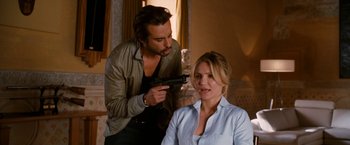 Movie still from “Knight and Day” (2010), directed by James Mangold – A man and a woman holding guns in a room; Medium shot, Over the shoulder angle