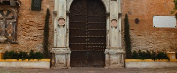 Movie still from “Knight and Day” (2010), directed by James Mangold – An old church door with a large arch and two large pillars; Extreme Wide shot, Low angle