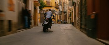 Movie still from “Knight and Day” (2010), directed by James Mangold – Two people riding a motorcycle down a street; Wide shot, Low angle