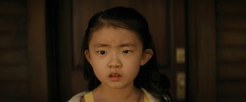 Movie still from “Knock at the Cabin” (2023), directed by M. Night Shyamalan – A little girl with long black hair is looking at the camera; Close Up shot, High angle