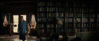 Movie still from “Knock at the Cabin” (2023), directed by M. Night Shyamalan – A living room filled with lots of books on a bookshelf; Wide shot, High angle