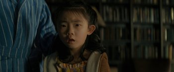 Movie still from “Knock at the Cabin” (2023), directed by M. Night Shyamalan – A little girl with long black hair looking at the camera; Close Up shot, Over the shoulder angle