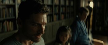 Movie still from “Knock at the Cabin” (2023), directed by M. Night Shyamalan – A man and a little girl in front of a book shelf; Close Up shot, Over the shoulder angle