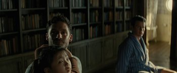 Movie still from “Knock at the Cabin” (2023), directed by M. Night Shyamalan – A man and a little girl in front of a bookcase; Close Up shot, Over the shoulder angle