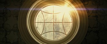 Movie still from “Knock at the Cabin” (2023), directed by M. Night Shyamalan – The sun is shining through a circular window; Extreme Close Up shot, Low angle