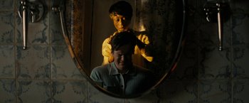 Movie still from “Knock at the Cabin” (2023), directed by M. Night Shyamalan – A man getting his hair cut in the mirror; Close Up shot, Over the shoulder angle