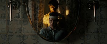 Movie still from “Knock at the Cabin” (2023), directed by M. Night Shyamalan – A man and a woman looking in a mirror; Medium shot, Low angle