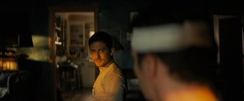 Movie still from “Knock at the Cabin” (2023), directed by M. Night Shyamalan – A man is taking a picture of another man in a room; Close Up shot, Over the shoulder angle
