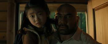 Movie still from “Knock at the Cabin” (2023), directed by M. Night Shyamalan – A man and a little girl are posing for a picture; Close Up shot, Over the shoulder angle