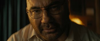 Movie still from “Knock at the Cabin” (2023), directed by M. Night Shyamalan – A person wearing glasses and a white shirt; Extreme Close Up shot, Low angle