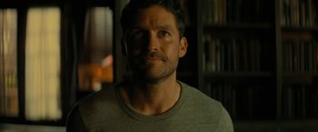 Movie still from “Knock at the Cabin” (2023), directed by M. Night Shyamalan – A person wearing a gray t - shirt; Close Up shot, Over the shoulder angle