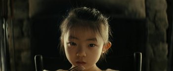 Movie still from “Knock at the Cabin” (2023), directed by M. Night Shyamalan – A little girl is eating a piece of food; Close Up shot, High angle