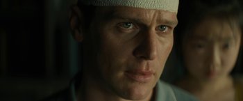 Movie still from “Knock at the Cabin” (2023), directed by M. Night Shyamalan – A person wearing a bandage on his head; Close Up shot, Low angle