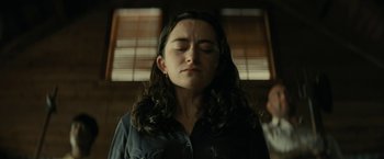 Movie still from “Knock at the Cabin” (2023), directed by M. Night Shyamalan – A woman with her eyes closed in front of a window; Close Up shot, Low angle