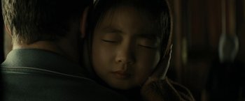 Movie still from “Knock at the Cabin” (2023), directed by M. Night Shyamalan – A little girl with her eyes closed with her head tilted to the side; Close Up shot, Over the shoulder angle