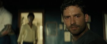 Movie still from “Knock at the Cabin” (2023), directed by M. Night Shyamalan – A person in a dark room; Close Up shot, Over the shoulder angle