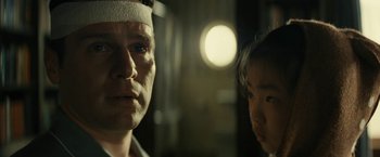 Movie still from “Knock at the Cabin” (2023), directed by M. Night Shyamalan – A man and a woman wearing bandages looking at the camera; Close Up shot, Over the shoulder angle