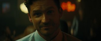 Movie still from “Knock at the Cabin” (2023), directed by M. Night Shyamalan – A person wearing a suit and tie; Close Up shot, Over the shoulder angle