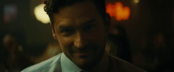 Movie still from “Knock at the Cabin” (2023), directed by M. Night Shyamalan – A person wearing a suit and tie; Close Up shot, Over the shoulder angle