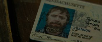 Movie still from “Knock at the Cabin” (2023), directed by M. Night Shyamalan – A massachusetts id card; Extreme Close Up shot, Overhead angle