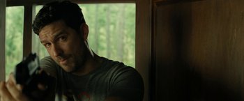 Movie still from “Knock at the Cabin” (2023), directed by M. Night Shyamalan – A person wearing a gray t - shirt; Close Up shot, Over the shoulder angle