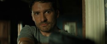 Movie still from “Knock at the Cabin” (2023), directed by M. Night Shyamalan – A person with a gun; Close Up shot, Over the shoulder angle