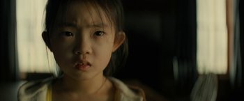 Movie still from “Knock at the Cabin” (2023), directed by M. Night Shyamalan – A young girl's face in the dark; Close Up shot, High angle