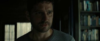 Movie still from “Knock at the Cabin” (2023), directed by M. Night Shyamalan – A person wearing a gray shirt; Close Up shot, Over the shoulder angle