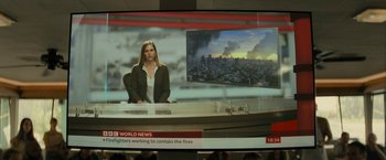 Movie still from “Knock at the Cabin” (2023), directed by M. Night Shyamalan – A woman sitting in front of a news desk; Extreme Close Up shot, Over the shoulder angle