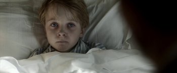 Movie still from “Kon-Tiki” (2012), directed by Espen Sandberg – A young boy laying in a bed with a white sheet; Close Up shot, High angle
