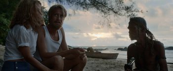 Movie still from “Kon-Tiki” (2012), directed by Espen Sandberg – A man sitting on the beach near the water; Medium shot, Over the shoulder angle