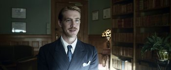 Movie still from “Kon-Tiki” (2012), directed by Espen Sandberg – A man wearing a suit and tie in a room; Close Up shot, Low angle