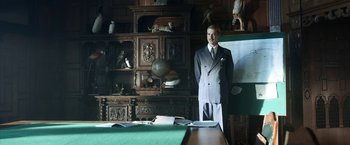 Movie still from “Kon-Tiki” (2012), directed by Espen Sandberg – A man in a suit standing in front of a desk; Medium shot, Over the shoulder angle