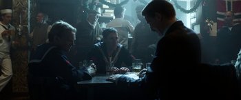 Movie still from “Kon-Tiki” (2012), directed by Espen Sandberg – A group of men sitting at a table in a room; Medium shot, Over the shoulder angle