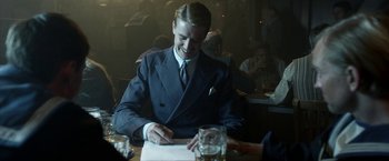 Movie still from “Kon-Tiki” (2012), directed by Espen Sandberg – A man sitting at a table writing on a piece of paper; Medium shot, Over the shoulder angle