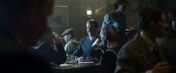 Movie still from “Kon-Tiki” (2012), directed by Espen Sandberg – A group of people sitting at a table with drinks; Medium shot, Over the shoulder angle