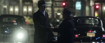 Movie still from “Kon-Tiki” (2012), directed by Espen Sandberg – Two men shaking hands on the side of the street; Medium shot, Over the shoulder angle