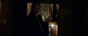 Movie still from “Kon-Tiki” (2012), directed by Espen Sandberg – A man standing in a dark room in front of a lamp; Medium shot, Over the shoulder angle