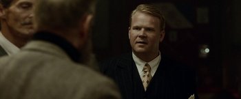 Movie still from “Kon-Tiki” (2012), directed by Espen Sandberg – A man wearing a suit and tie talking to another man in a suit; Close Up shot, Over the shoulder angle