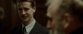 Movie still from “Kon-Tiki” (2012), directed by Espen Sandberg – A person wearing a suit and tie; Close Up shot, Over the shoulder angle