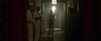 Movie still from “Kon-Tiki” (2012), directed by Espen Sandberg – A group of men standing in a hallway talking on cellphones; Wide shot, Low angle