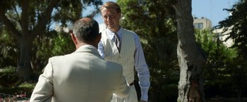 Movie still from “Kon-Tiki” (2012), directed by Espen Sandberg – A man in a suit and tie talking to another man; Medium shot, Over the shoulder angle