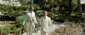 Movie still from “Kon-Tiki” (2012), directed by Espen Sandberg – Two men in white suits and ties standing next to each other on a walkway; Medium shot, Over the shoulder angle