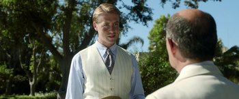 Movie still from “Kon-Tiki” (2012), directed by Espen Sandberg – A man in a suit and tie standing next to another man in a hat; Medium shot, Over the shoulder angle