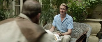 Movie still from “Kon-Tiki” (2012), directed by Espen Sandberg – A man sitting on a chair with a book in his hand; Medium shot, Over the shoulder angle