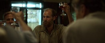Movie still from “Kon-Tiki” (2012), directed by Espen Sandberg – A man holding up a glass of wine in his right hand; Medium shot, Low angle