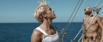 Movie still from “Kon-Tiki” (2012), directed by Espen Sandberg – A man with blonde hair is standing on a sailboat; Close Up shot, Low angle