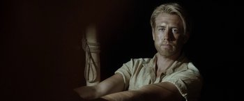 Movie still from “Kon-Tiki” (2012), directed by Espen Sandberg – A man sitting in front of a candle in a dark room; Close Up shot, Over the shoulder angle