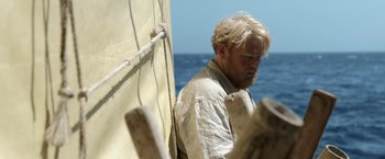 Movie still from “Kon-Tiki” (2012), directed by Espen Sandberg – A man standing on a boat in the water; Close Up shot, High angle